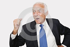 Aggressive elderly businessman against white background