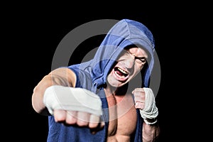 Aggressive fighter punching against black background