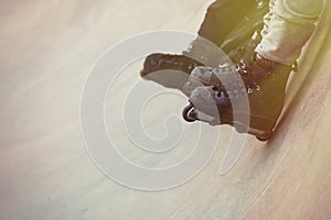 Aggressive inline rollerblader sitting on ramp in skatepark