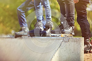 Aggressive inline rollerblader standing on ramp in skatepark