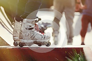 Aggressive inline rollerblader standing on ramp in skatepark