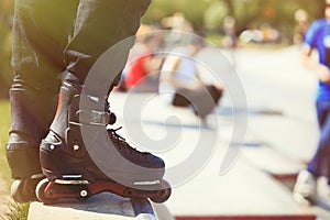 Aggressive inline rollerblader standing on ramp in skatepark