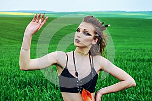 Aggressive makeup girl, amazon character in a green wheat field