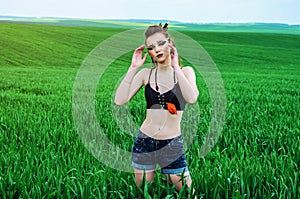 Aggressive makeup girl, amazon character in a green wheat field