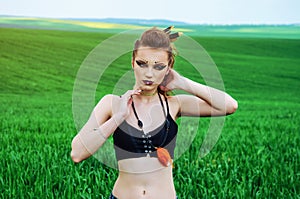 Aggressive makeup girl, amazon character in a green wheat field