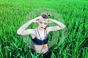 Aggressive makeup girl, amazon character in a green wheat field