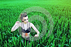 Aggressive makeup girl, amazon character in a green wheat field