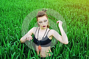 Aggressive makeup girl, amazon character in a green wheat field