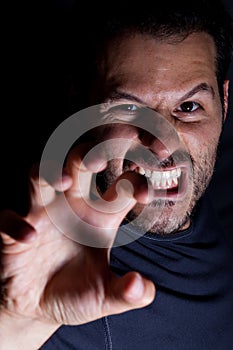 Aggressive man attacks with his hand in a scary night scene