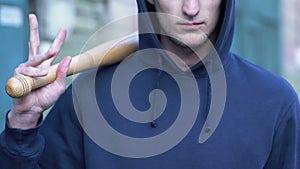 Aggressive man holding baseball bat ready to attack, street groupings of bully