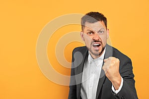 Aggressive man on orange background, space for text