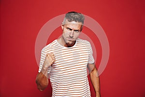 Aggressive man in striped t-shirt looking with loathing and show