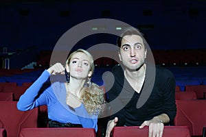 Aggressive man and woman watch movie and root for movie characters