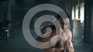 Aggressive professional fighter training shadow boxing throwing a vicious blow. A young champion is practicing box at a