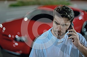 Aggressive talk. Serious driver man talking on phone on night urban street. Aggressive driver man talking on phone