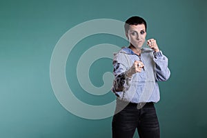 Aggressive upset young adult doing fighting gesture in studio