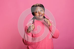 Aggressive woman clenching fists and showing raised knuckles on camera in studio