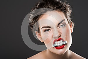 aggressive woman holding dollar banknote in teeth