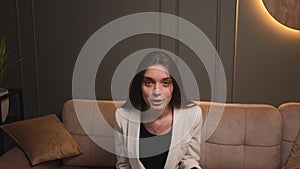 aggressive woman speaking looking at camera talking make video conference on couch at home office. Doing video chat at