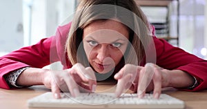 Aggressive woman is typing on computer keyboard in office