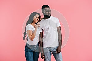 aggressive young african american woman showing fist while her boyfriend standing near