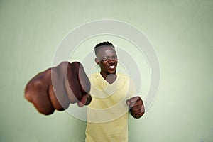 Aggressive young african man punching with fist