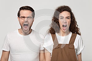 Aggressive young man and angry millennial woman shouting, screaming together.