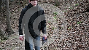 Aggressive young man walking alone in forest, annoyed with life, disappointment