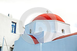 Agia Kyriaki Church, typical Greek church white building with red dome against the blue sky on the island Mykonos