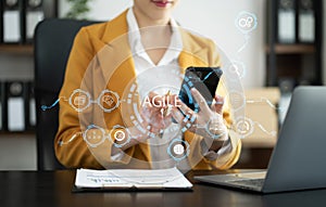 Agile development methodology concept. Business hand using laptop computer and tablet with virtual screen agile icon on modern