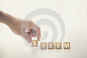 Agile and Scrum in Software Development concepts, Hand pick wooden cube and place with text to fill the word SCRUM. Brochure