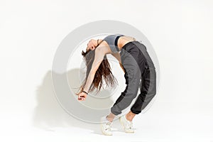 Agile supple young woman doing a modern hip hop dance pose photo