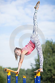 Agile young gymnast balancing on cross bars