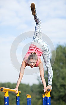 Agile young gymnast balancing on cross bars