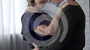 Aging couple dancing and hugging date, lady smiling playfully, loving relations