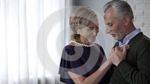 Aging couple dancing, male tenderly holding ladys hand, feeling nostalgic