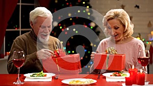 Aging couple opening presents on Christmas eve, tender relations through years