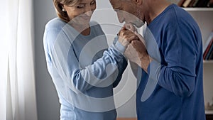 Aging male holding woman hands and kissing them, lady feeling shy, attraction