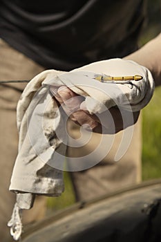 Older man alone on route checking unfunctional engine in late summer light