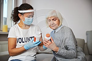 Aging woman and caretaker reading the pills instructions