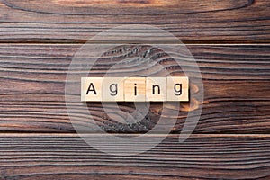 Aging word written on wood block. Aging text on wooden table for your desing, concept