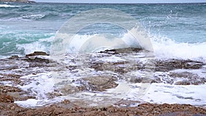 Agitated sea waves against rocks in the beach, 4K