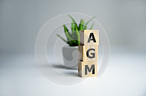 AGM Annual general meeting acronym on wooden cubes on dark wooden backround. Business concept