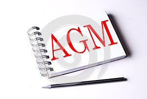 AGM word on notebook on white background