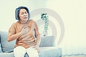 An agonizing elderly woman is experiencing chest pain.