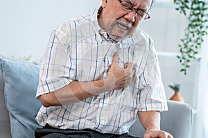 An agonizing senior man suffering from chest pain or heart attack.