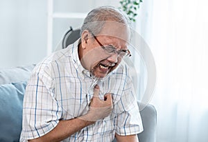 An agonizing senior man suffering from chest pain or heart attack.