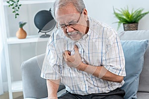 An agonizing senior man suffering from chest pain or heart attack.