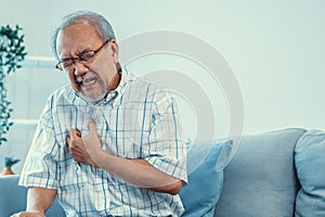 An agonizing senior man suffering from chest pain or heart attack.