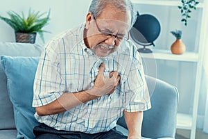 An agonizing senior man suffering from chest pain or heart attack.